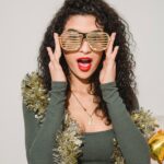 excited woman with red lips in striped glasses and tinsel